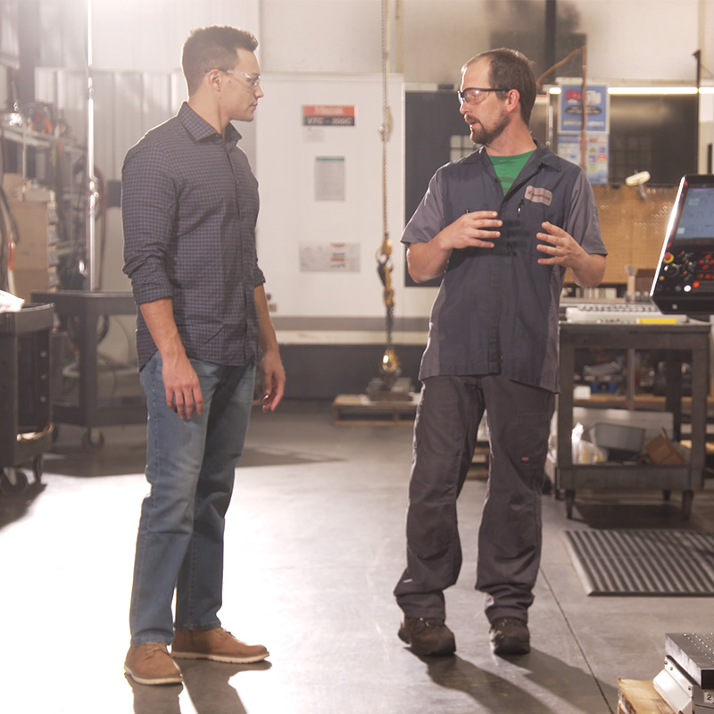 Michael Alfonso speaking with a factory worker