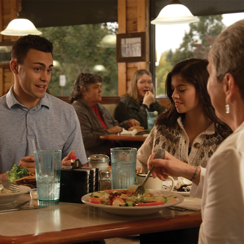 Michael Alfonso, Evita Duffy-Alfonso, and family smiling at a restaurant