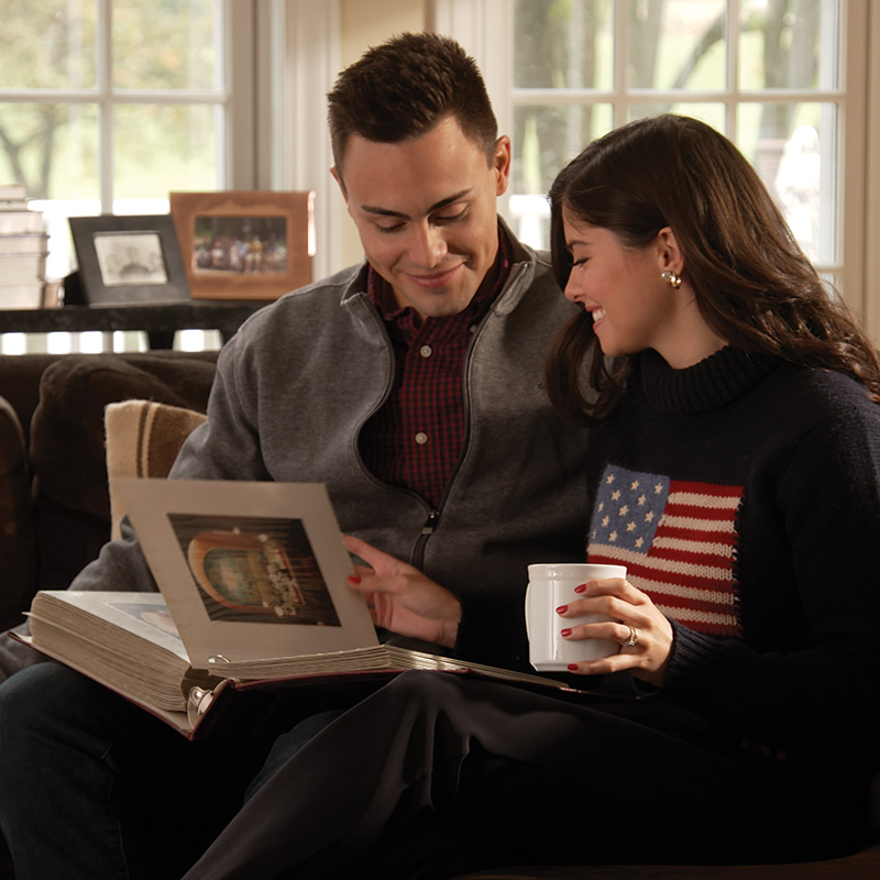 Michael Alfonso and his wife, Evita Duffy-Alfonso, smiling while looking through photos